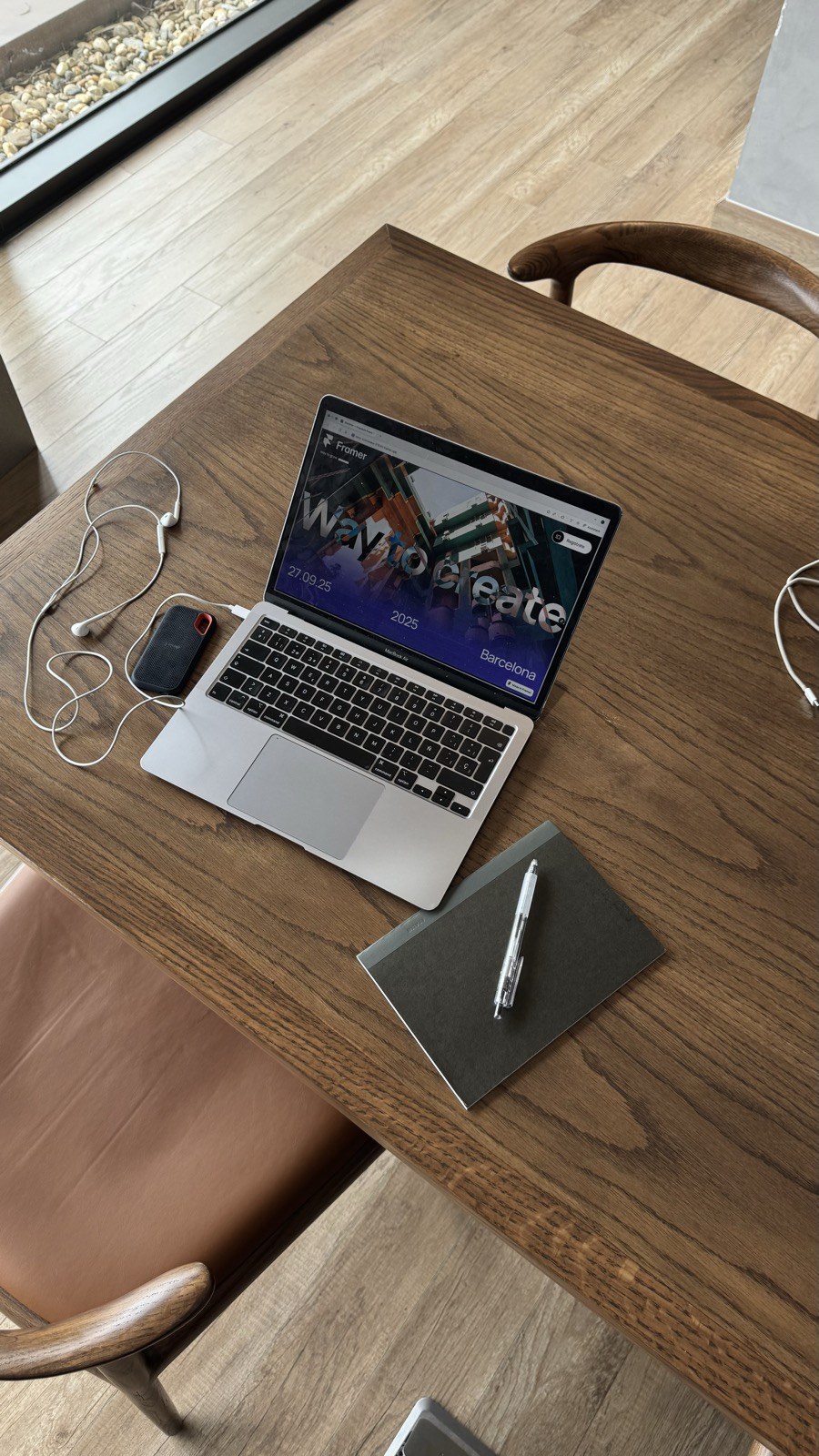 Portátil y material de trabajo sobre una mesa de madera.